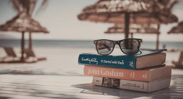 Vacation photo by the beach, sunglasses and books