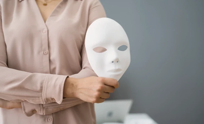 Mujer llevando una máscara para llamar la atención sobre el fraude en Internet.