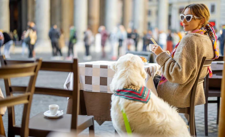 signora che prende un caffè in una piazza italiana con il suo cane